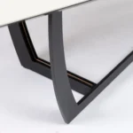 طاولة طعام سيراميك بيضاء بقاعدة معدنية سوداء مزينة بتفاصيل ذهبية في غرفة طعام عصرية